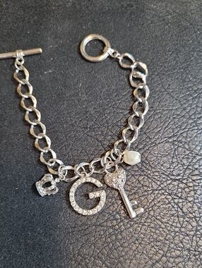 Guess Silver Tone Charm Bracelet with G Initial, Key & Pearl And Crown Accent